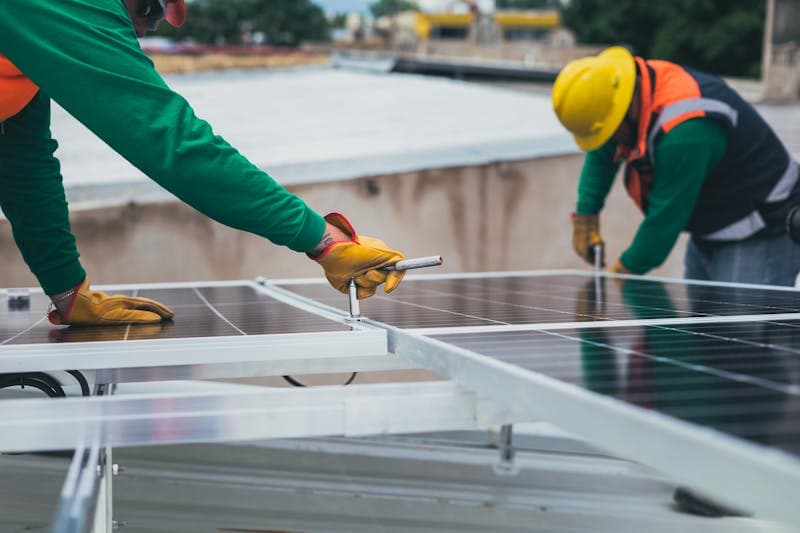 Specialist care instalează panouri solare pe acoperiș cu elemente de prindere vizibile