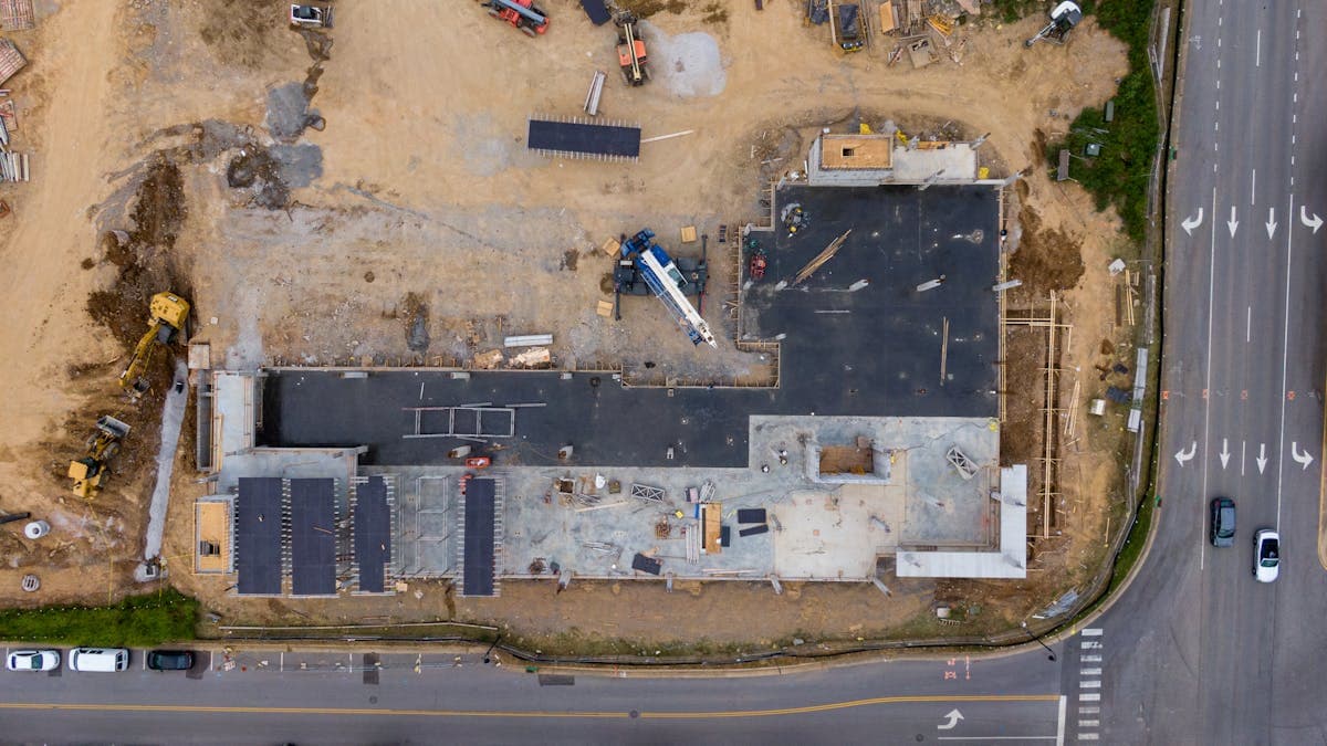 Semnarea unui contract de construcție cu plan arhitectural pe masă